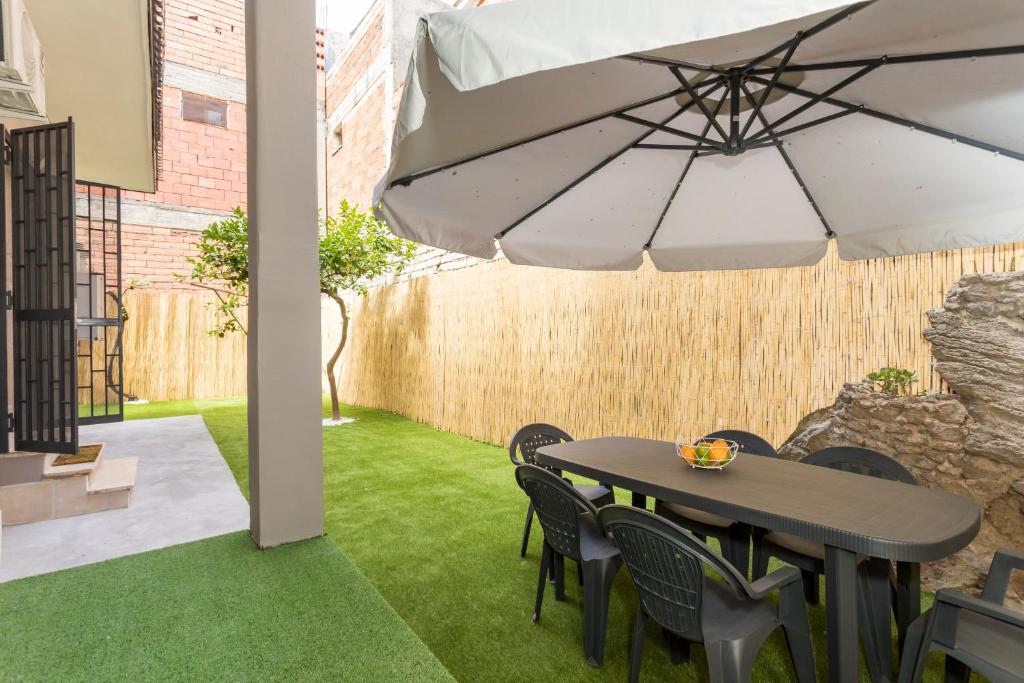 a patio with a table and chairs and an umbrella at Etnamia Art in Paterno