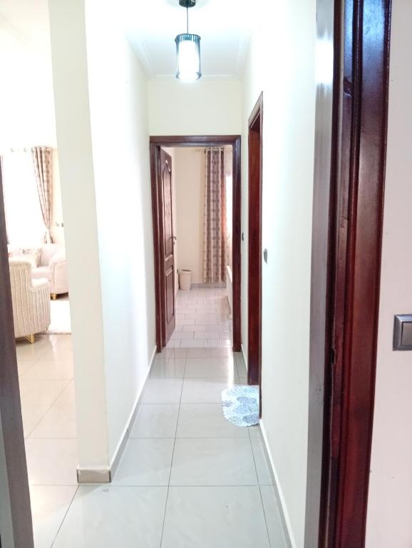 a hallway with white walls and white tile floors at Amidez Apparts in Zalom