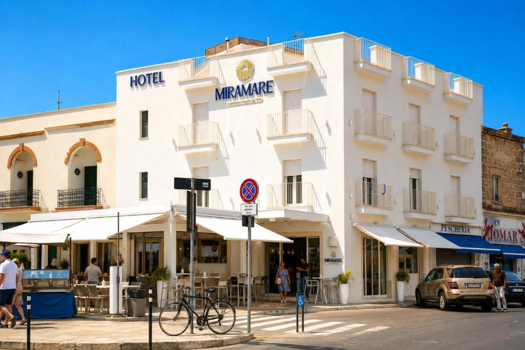 a large white building on a city street at Hotel Miramare in Porto Cesareo