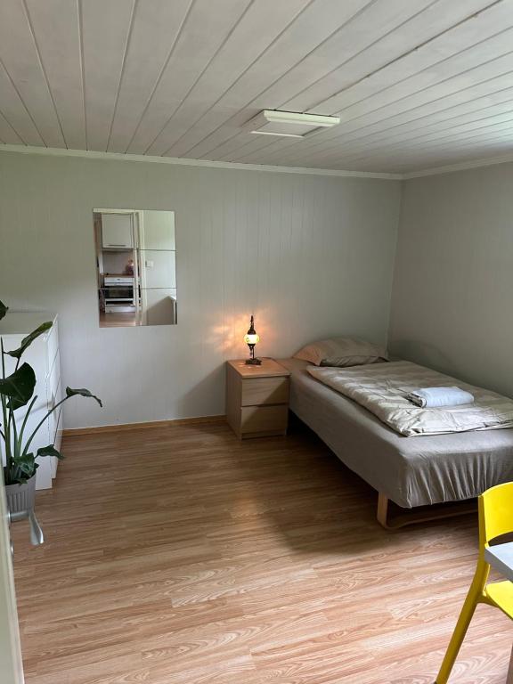 a bedroom with a bed and a table and a lamp at Room in a shared apartment in Trondheim