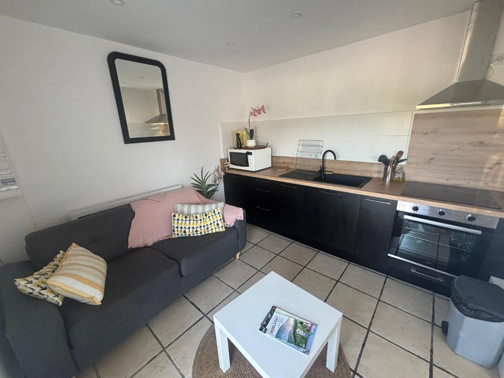 a living room with a couch and a kitchen at Apartment with mountain view in Espelette
