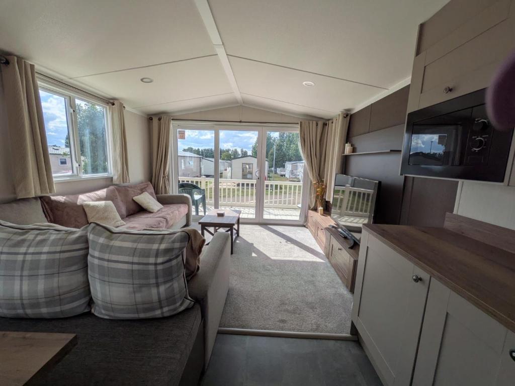 a living room with two couches and a tv and a balcony at Seaside Haven Hunstanton 2026 Model in Hunstanton