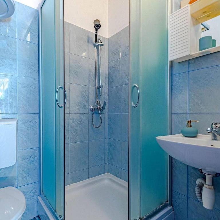 a bathroom with a shower and a sink at Apartmani Mila in Ubli