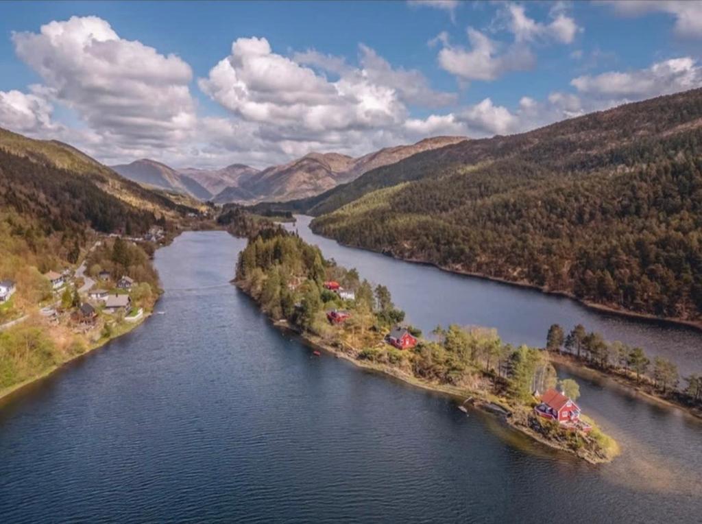 an aerial view of a river in a valley at Tinyhouse surrounding Norwegian mountains in Bergen