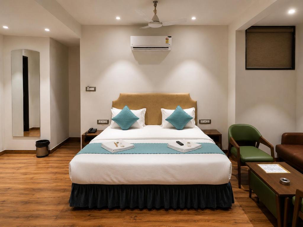 a hotel room with a bed and a couch at Hotel Nee Residency in Rajkot