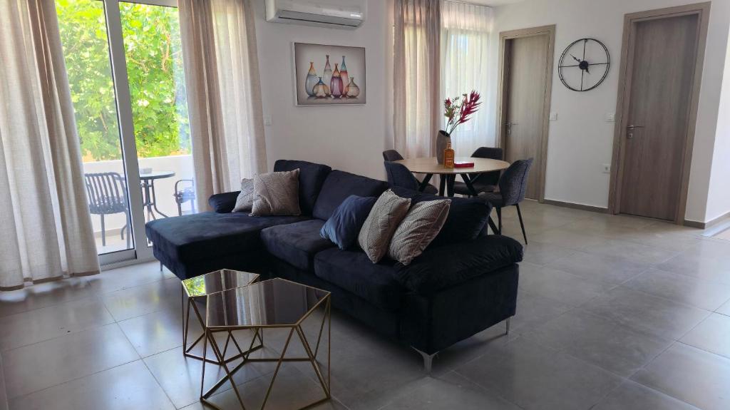 a living room with a blue couch and a table at Kos Cozy Home in Platánion