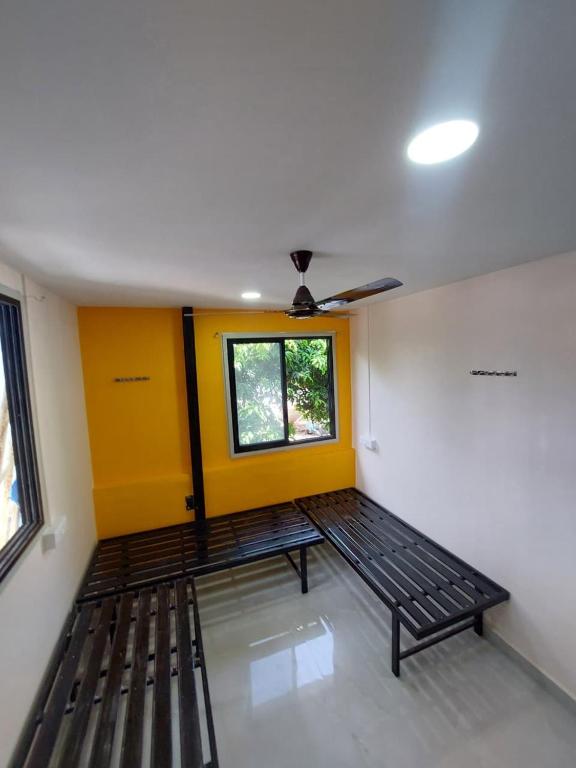 a room with a bed with a yellow door and a window at UrBan PG&HOSTEL Deluxe Triple Accommodation Boy's Only in Pune