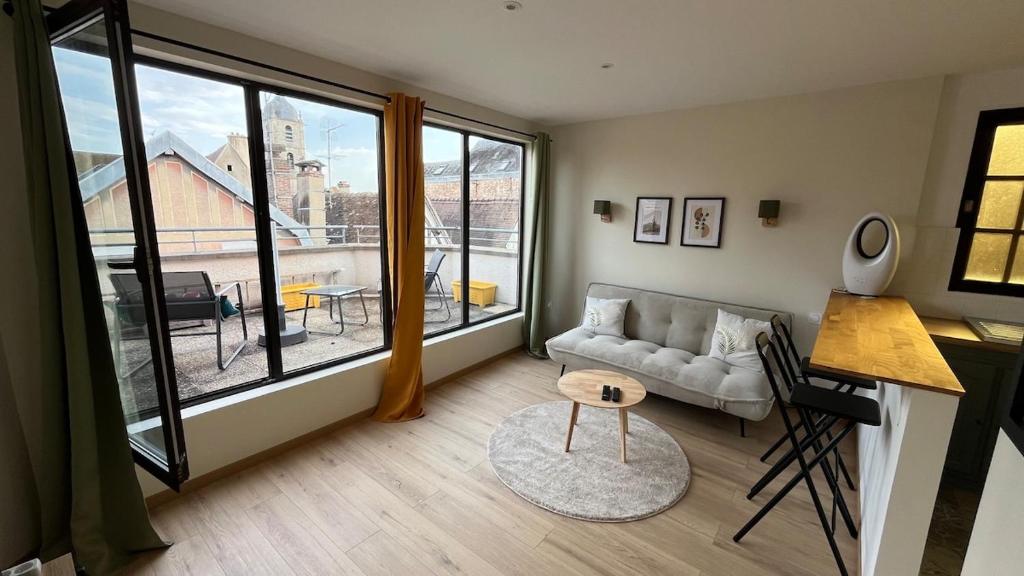 a living room with a couch and a large window at Duplex Signature - Downtown - Sens in Sens