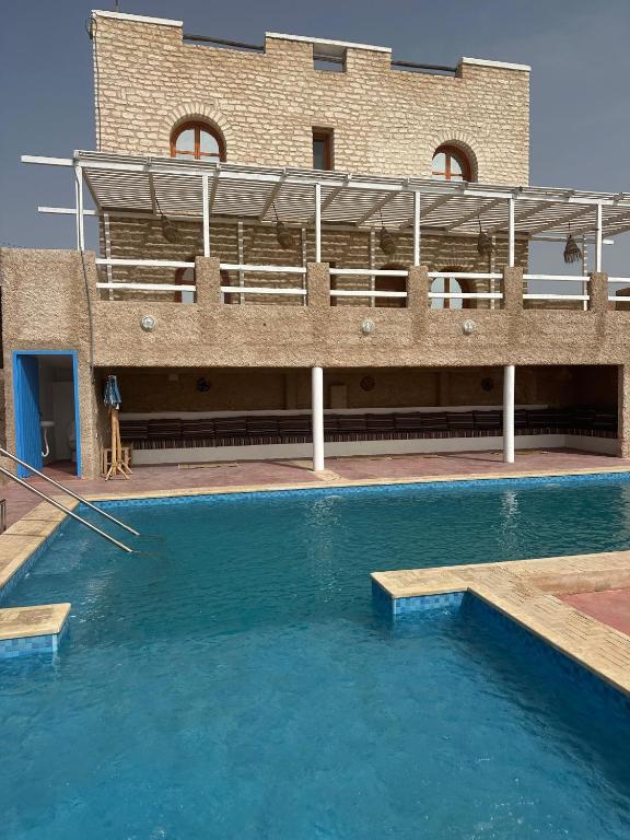 a large swimming pool in front of a building at Tigmi berber in Essaouira