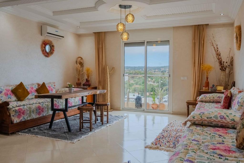 a living room with a table and a couch at appartement chaleureux essaouira in Essaouira
