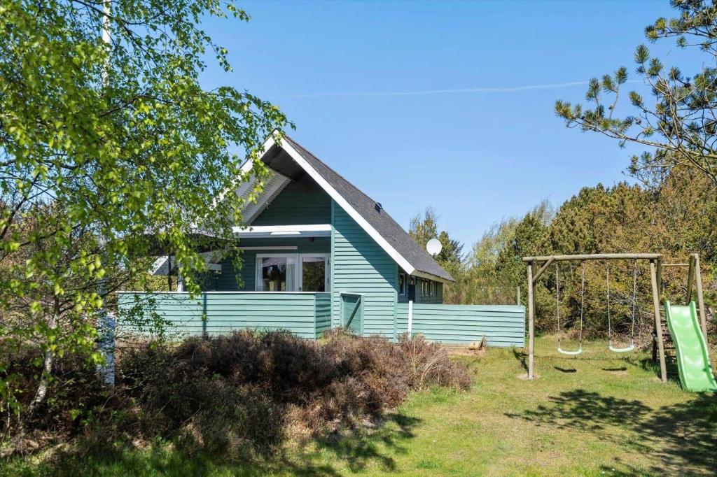 a blue house with a playground in front of it at 0008-Romo-Froidal-24 in Høm