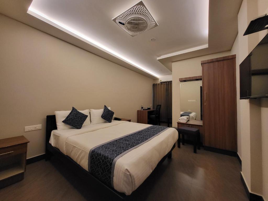 a hotel room with a bed and a desk at Hotel Grand Vista in Cochin
