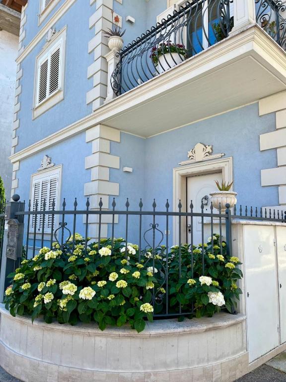 a blue house with a fence and flowers at Blue House in Martinsicuro