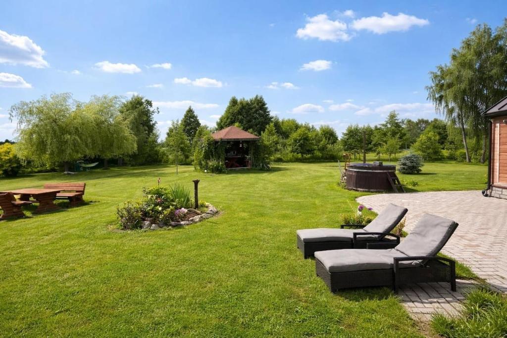 a yard with two chairs and a gazebo at Upes lillijas in Jelgava