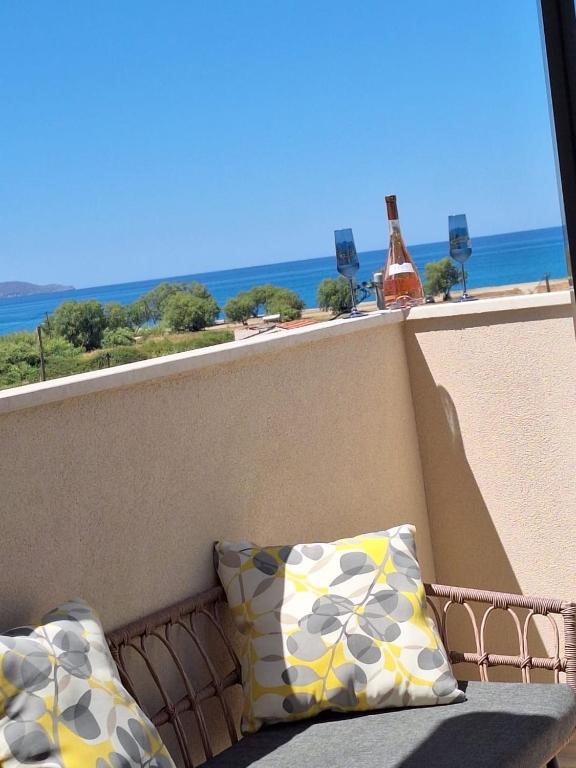 a balcony with a pillow and a bottle of wine at Villa Marcella by the Sea in Kamisianá