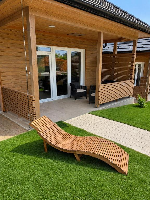 a wooden bench sitting on the grass in front of a house at V44 Resort in Visegrád