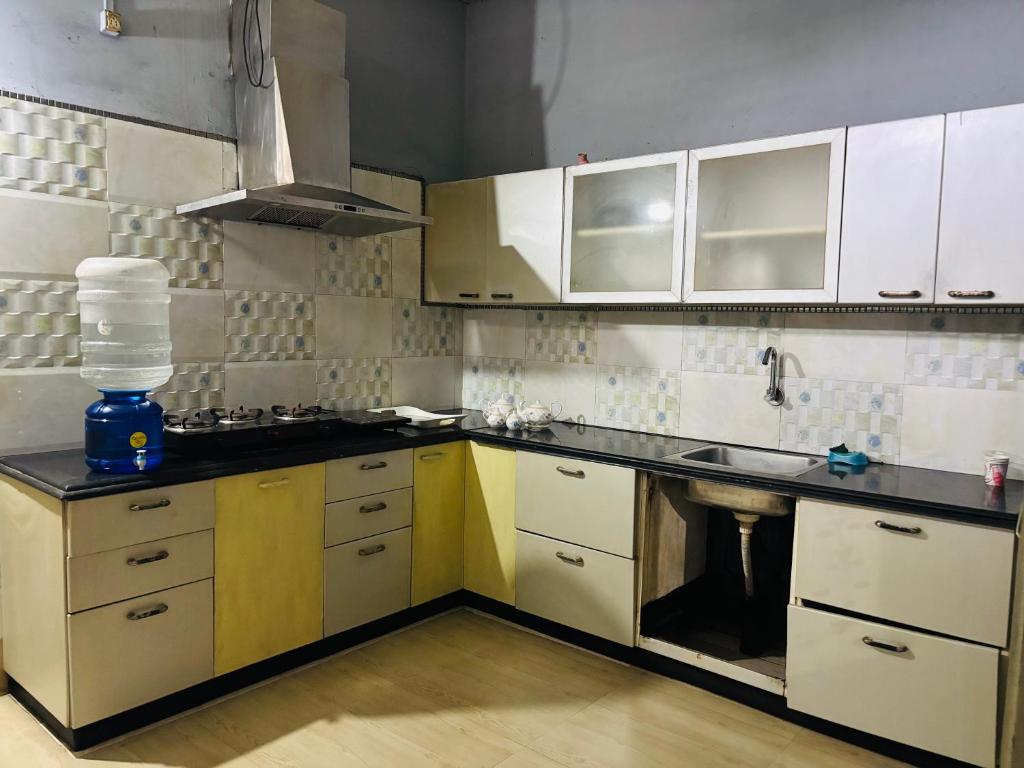 a kitchen with white cabinets and black counter tops at The Cloud9 Villa in Tezpur