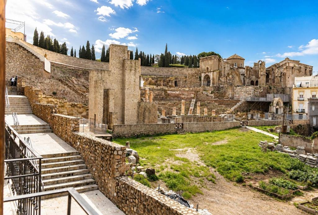 an ancient amphitheater with stairs and grass at Apartamentos Turísticos Teatro Romano by CartagenaSpain in Cartagena