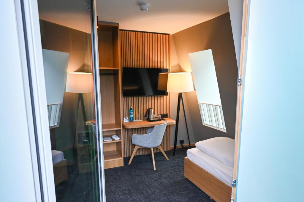 a hotel room with a bed and a desk with a computer at Hotel Spenerhaus - neu und vollklimatisiert in allen Zimmern in Frankfurt