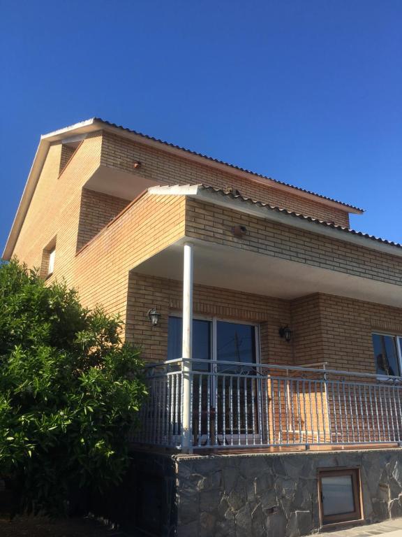 a brick house with a balcony on a clear day at Casa de Aurora in Rubí