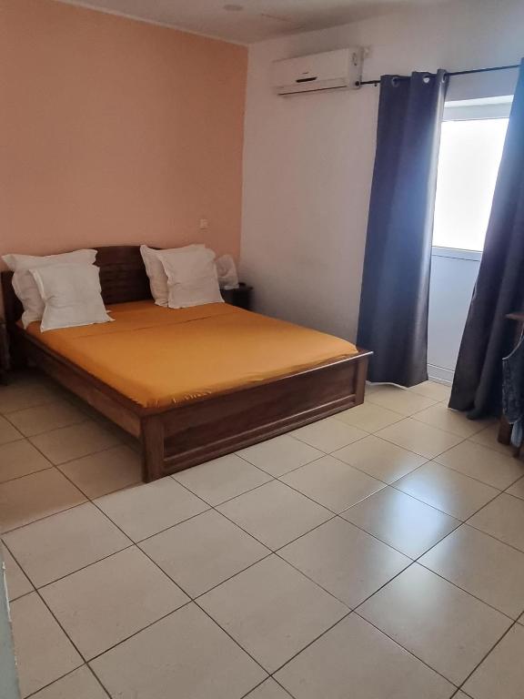 a bedroom with a bed in a room with a window at Hotel Bartaba in Antsiranana