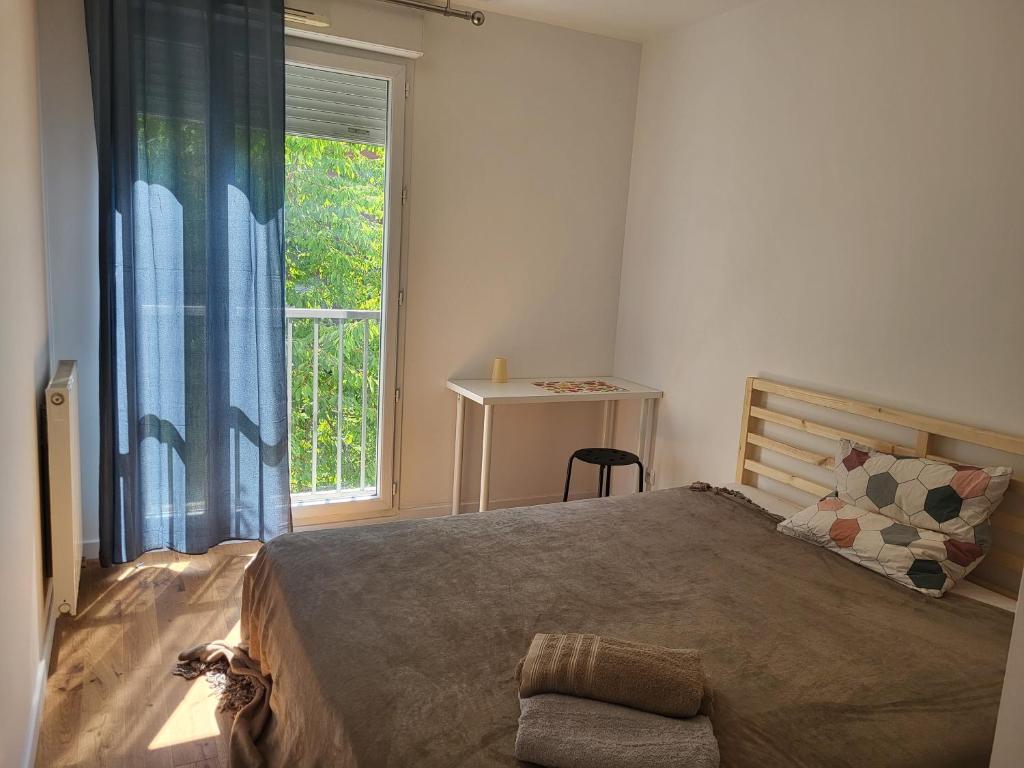 a bedroom with a large bed and a window at 1 chambre double privée et securisée dans un appart avec espace partagé in Saint-Denis