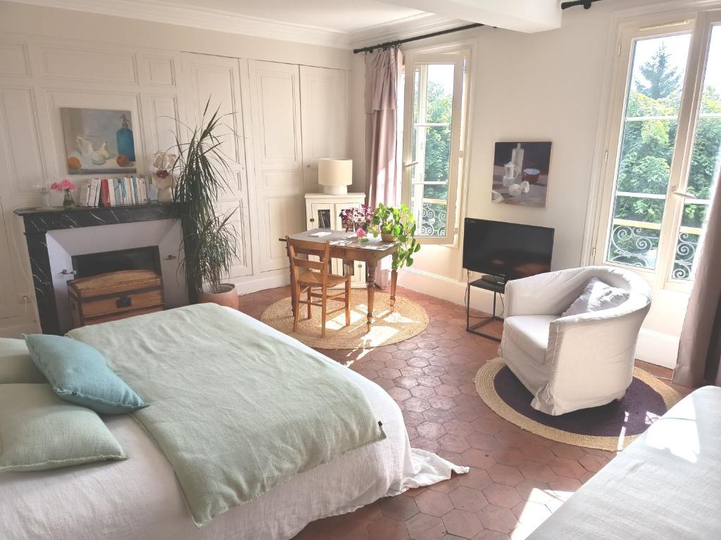 a bedroom with a bed and a chair and a table at Clos Florésine B&B in Venette