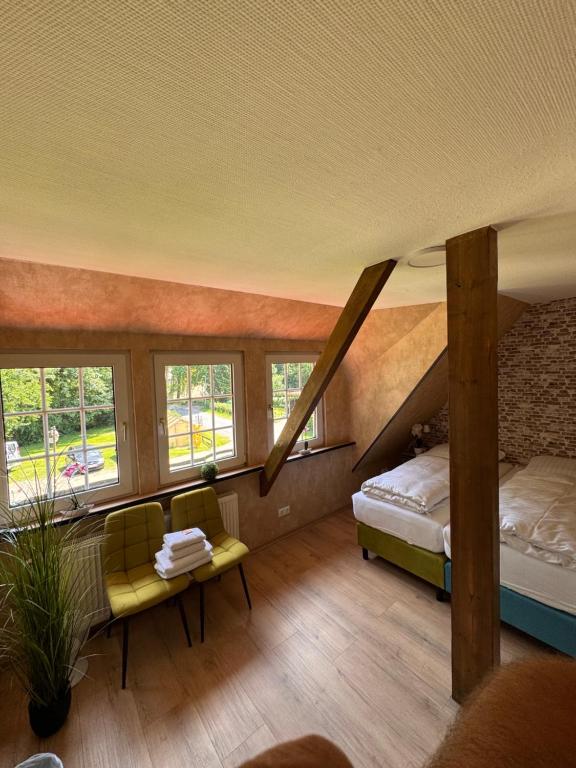 a room with a bed and a couch and windows at Ferienwohnung am Rohrbach in Binnen