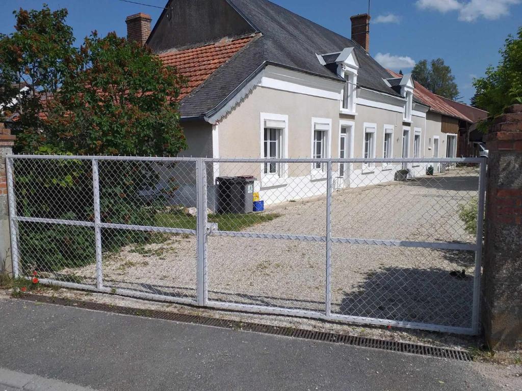 a chain link fence in front of a house at pastelle entre zoo et chateau in Contres