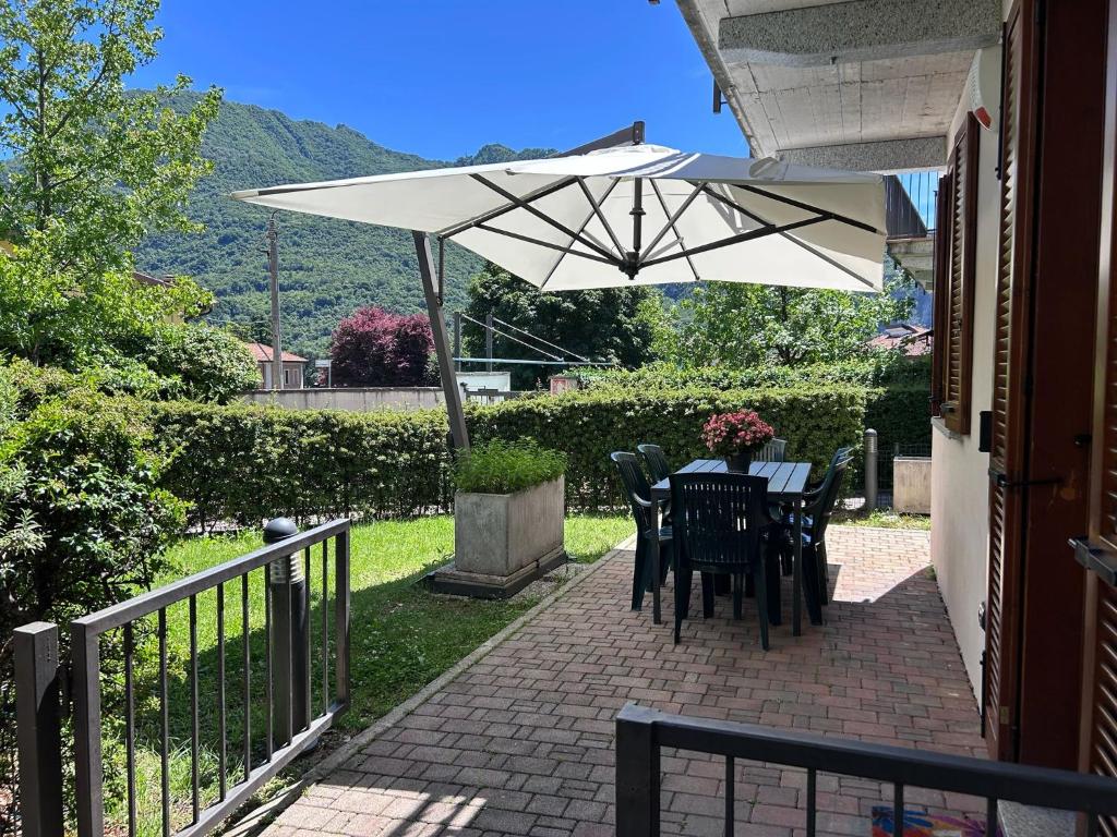 a table and chairs under an umbrella on a patio at Rosa dei Venti - Como Lake House in Valmadrera