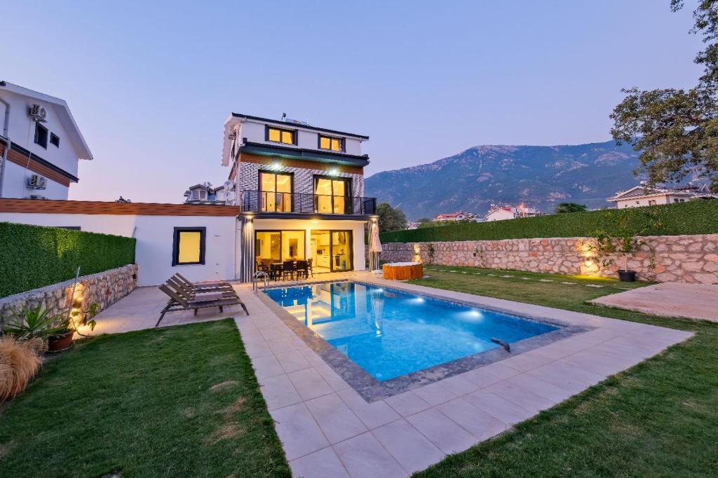 a house with a swimming pool in the yard at Villa Prestige 2 in Fethiye
