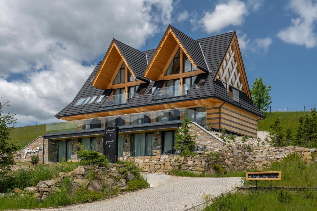 a house with a gambrel roof on top of it at TatryTop Giewont House Wellness in Kościelisko