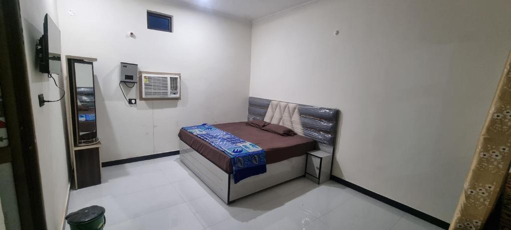 a small room with a bed in the corner at Anusthan Hotel in Ūnchāhar