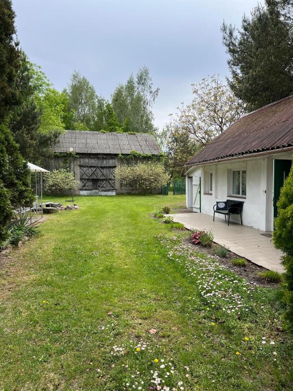 a yard with a house and a wooden deck at Agroturystyka Uroczysko Kostomłoty in Kostomłoty
