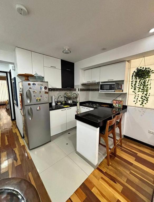 a kitchen with white cabinets and a stainless steel refrigerator at HOSPEDAJE HUIT STAr in Buenos Aires