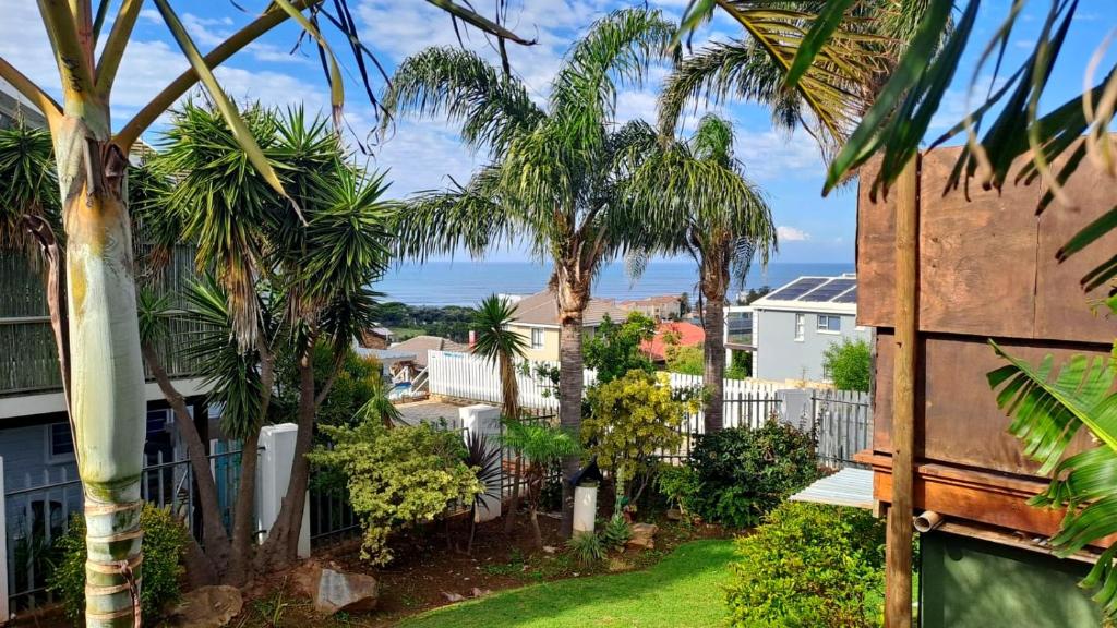 a view from the balcony of a house with palm trees at Ryans Surf Cabin in Jeffreys Bay