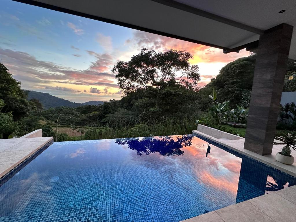 a swimming pool with a view of the sunset at Villa Montemar Ocean and Mountain Views in Platanillo