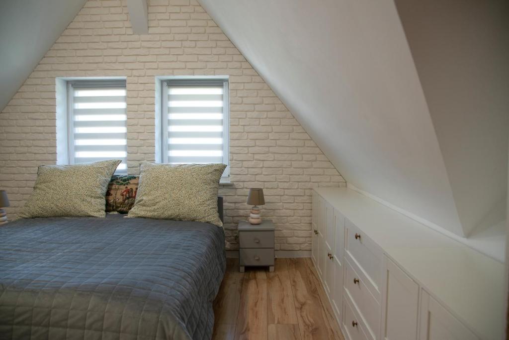 a bedroom with a bed and two windows at Pod Lwią Górą in Strużnica