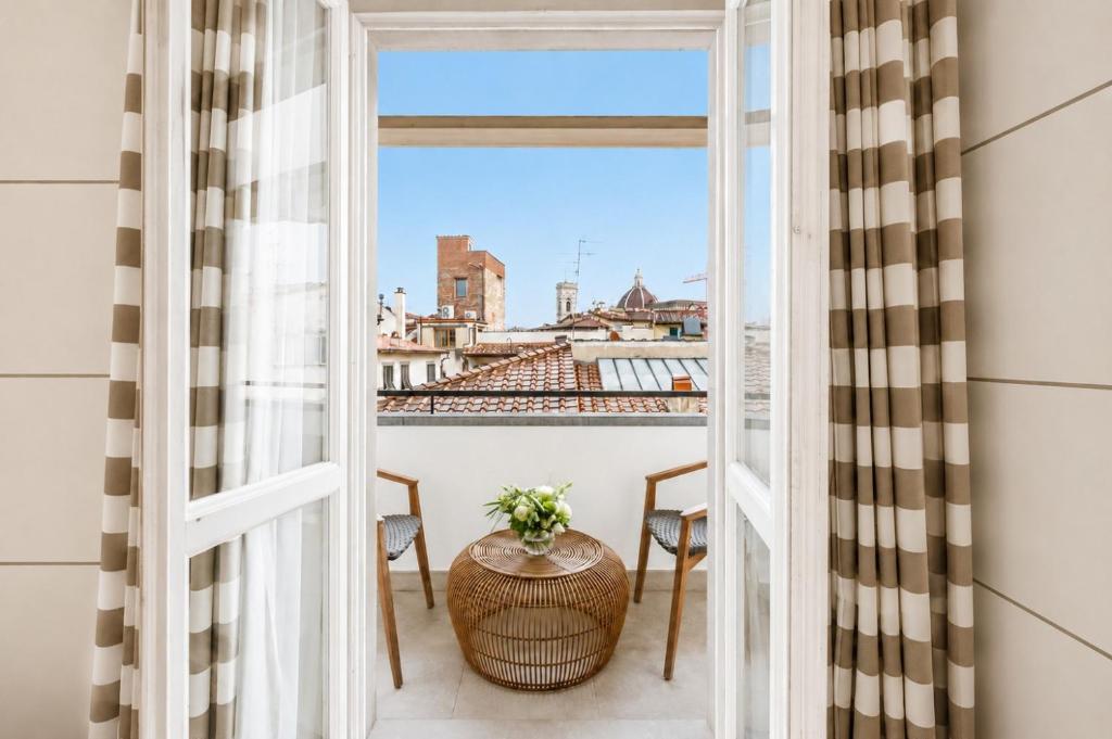 a room with a view of the city from a window at Gallery Hotel Art - Lungarno Collection in Florence