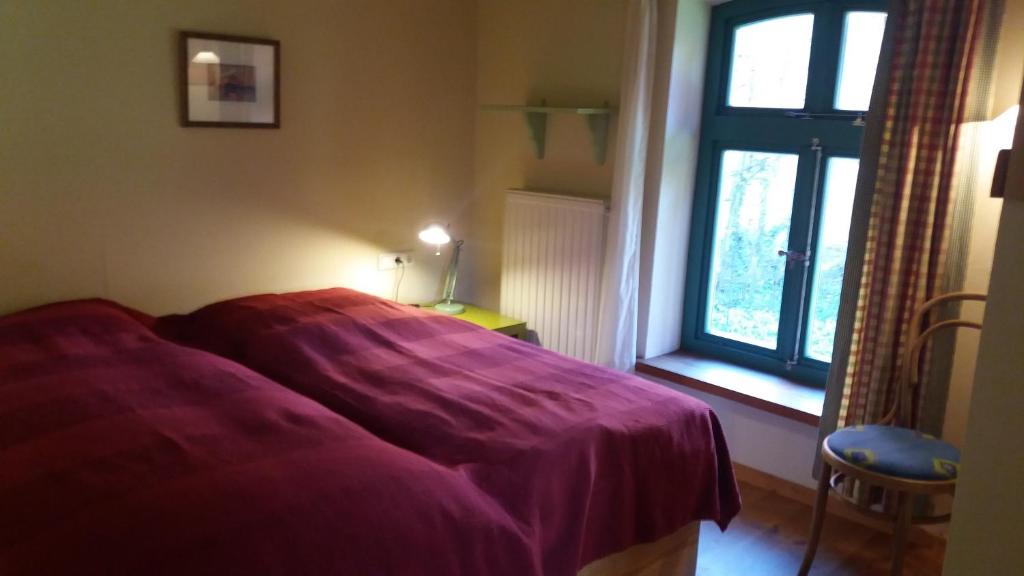 a bedroom with a purple bed and a window at Bülitz33 in Luckau