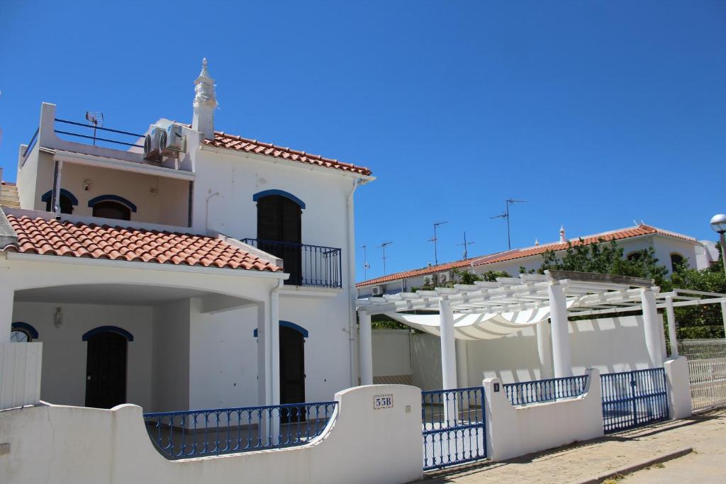 a white house with a red roof and white fences at Three Sisters in Altura