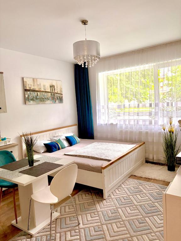 a bedroom with a bed and a table and a window at Kiki home in Oradea
