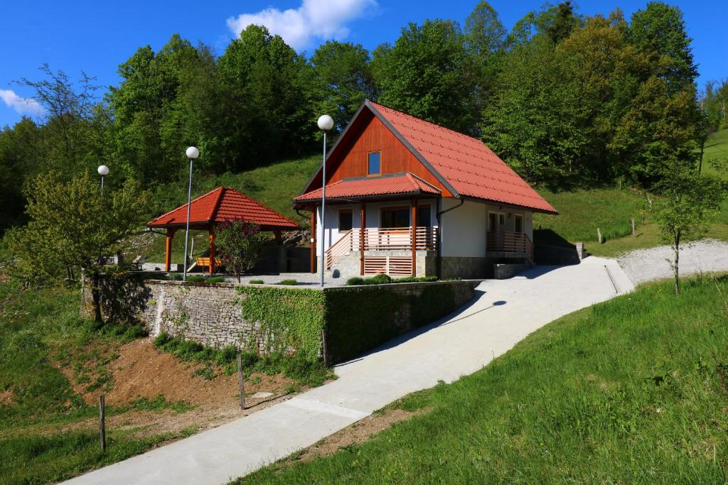 a small house with a red roof on a hill at Valley View Holiday Home with Sauna Mrak in Slap ob Idrijci