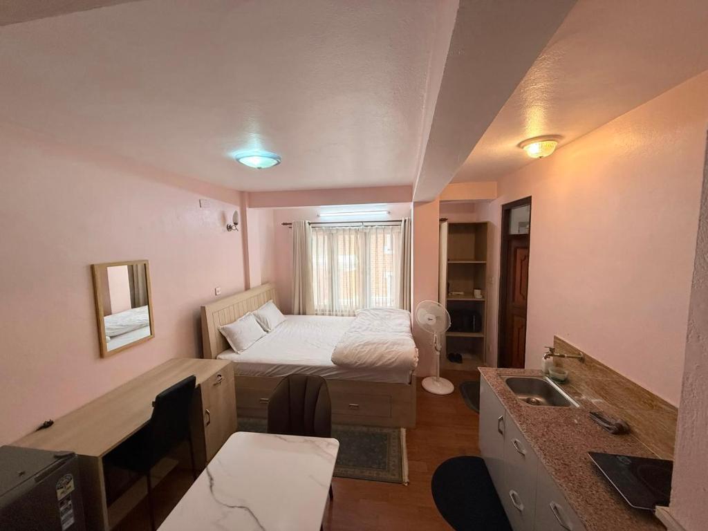 a small room with a bed and a sink at Lux Apartment in Kathmandu