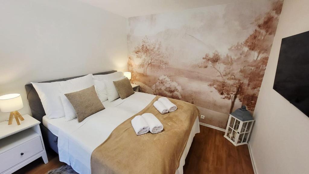 a bedroom with a bed with towels on it at Calma Apartments Gattendorf in Gattendorf