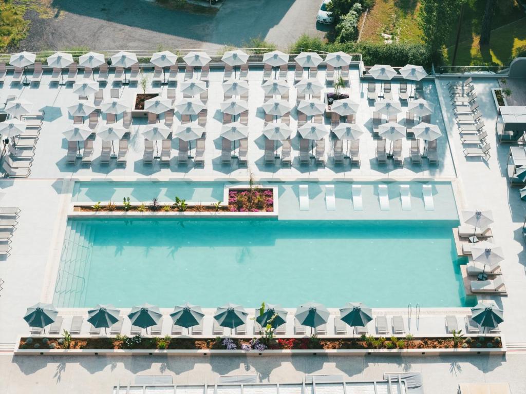 an aerial view of a hotel pool with white umbrellas at Iolida Corfu Resort by Smile Hotels in Dassia