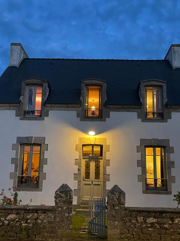 a white house with lights on the windows at Gîte ty nina rosa in Penmarch