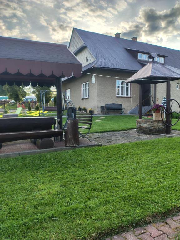 a house with a pavilion in front of a yard at Sielankowy Domek in Istebna