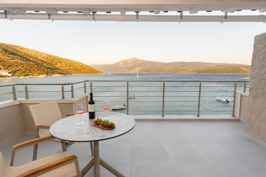 a balcony with a table and a view of the water at eu Τhea Apt Samos - Sandy Beach & Amazing View in Psili Ammos