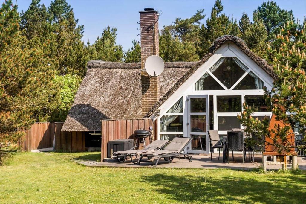 a house with a thatched roof with a patio at 0142-Romo-Ivigtut-1 in Høm
